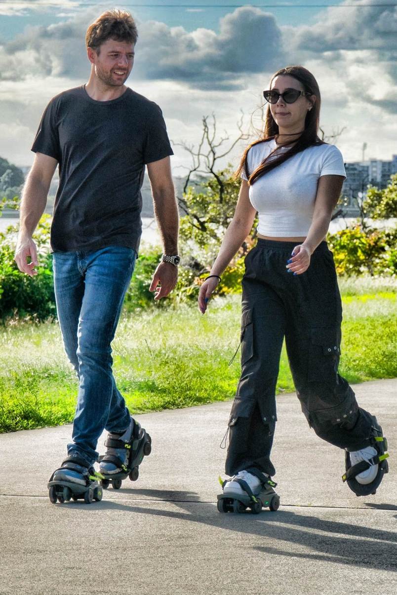 Man and woman riding motorized shoes on a path outdoors
