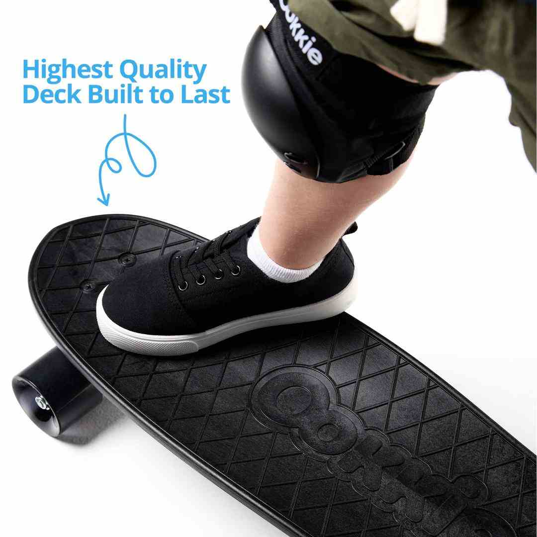 Child wearing knee pads standing on durable black skateboard deck