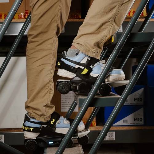 Person climbing metal stairs wearing motorized shoes indoors