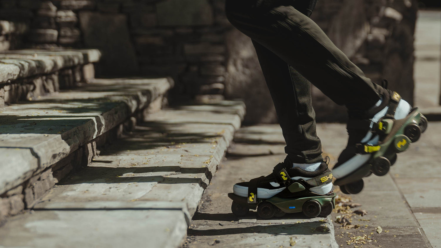 Person walking up stone steps wearing motorized shoes outdoors